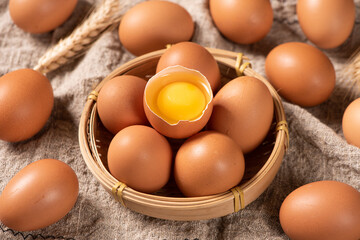 Broken raw egg with yolk on wooden table.