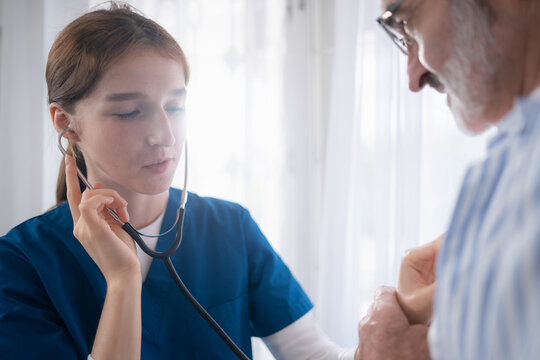 An elderly man and his doctor, standing by the window in the patient room