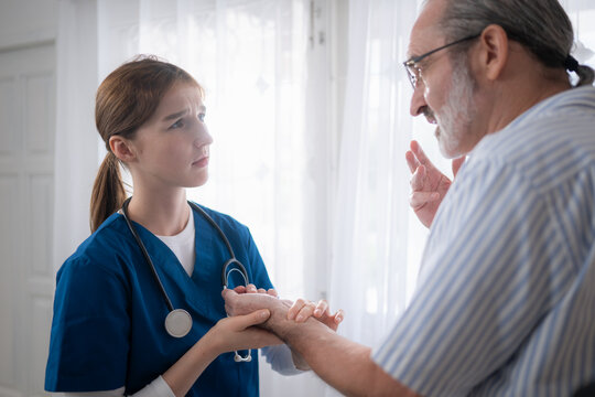 An elderly man and his doctor, standing by the window in the patient room