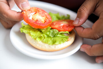 Delicious Veggie Burger Preparation With Fresh Tomatoes and Vibrant Lettuce