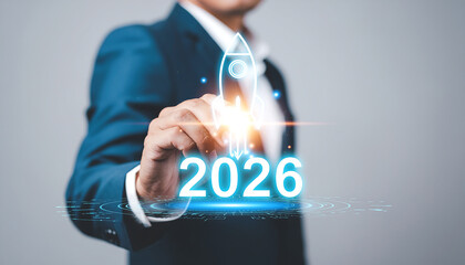 Businessman holding a glowing rocket symbol with the year 2026, representing future growth.