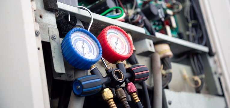 Air conditioning service,HVAC Using a gauge to check the refrigerant in the system. Concept of inspection and maintenance services