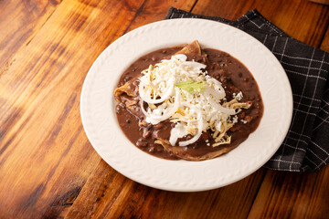 Enfrijoladas. Corn tortillas bathed in bean sauce, covered with cream and cheese, they can be covered or filled with chicken meat, chorizo, cheese or some other ingredient. Traditional Mexican dish.