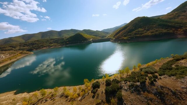 FPV drone flight above Spanish lake in fall season