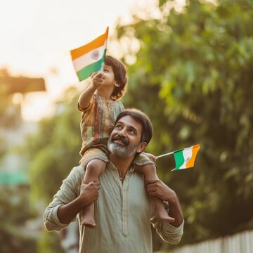 Happy indian father carrying his son on shoulders waving indian flags