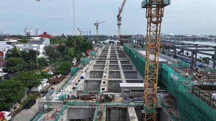 Fototapeta premium Aerial view Construction site with a crane and a large building in the background. The crane is on the left side of the image and the building is on the right side. middle city 