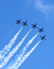 Six jets in formation with smoke trails in blue sky