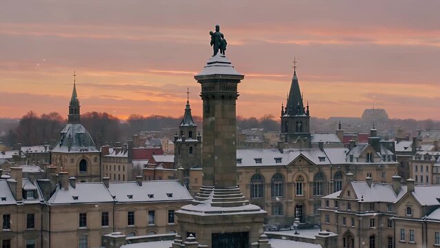 urban city center covered in a blanket of fresh snow during the evening with a monument in the