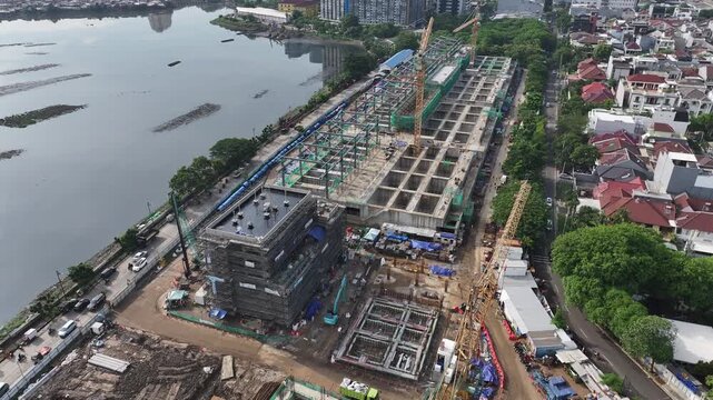 Aerial view  Construction site with a crane and a large building in the background. The crane is on the left side of the image and the building is on the right side. middle city 