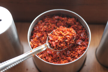 Spicy red chili flakes in a metal container