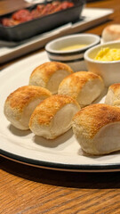 Few pieces of small bread with butter and sauce on white dish