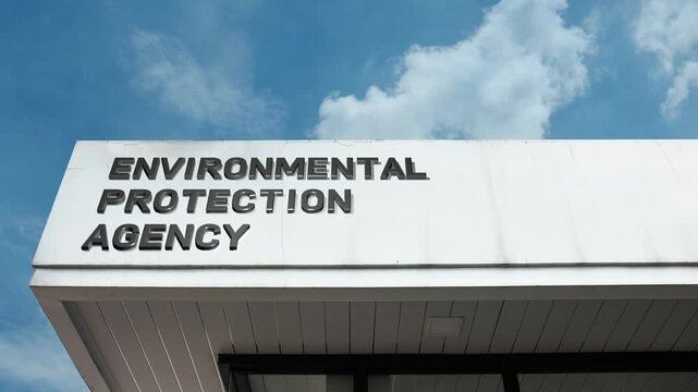 Environmental Protection Agency word sign prominently displayed on the official government building facade beneath a clear blue sky, signifying the body responsible for ecological health conservation
