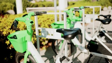 Cannes, France - October 13, 2025: Close up of green electric bicycles parked in a sunny city area - Powered by Adobe