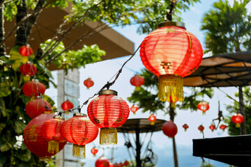 Red lanterns adorn trees and structures in a festive environment