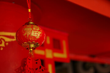 Red lantern with golden decorations suspended in a festive space © Atlas