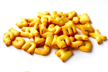 A pile of alphabet-shaped butter cookies arranged on a white background.