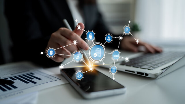 A businesswoman interacts with her smartphone and laptop, showcasing digital icons representing technology, data analytics, and connectivity in a modern workspace. Tessel