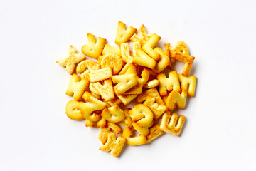 A pile of alphabet-shaped butter cookies arranged on a white background.
