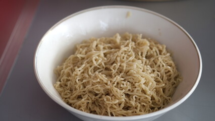 small plain noodles, without any added toppings, in a white bowl