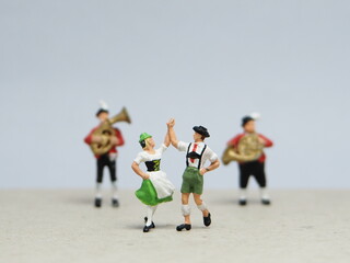 Mini toy of action figure at outdoor with blurred background. Miniature photography concept design. Minifigure of man and woman character dancing together at home.