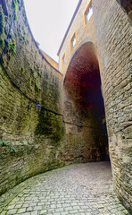 Castle of Sedan, Sedan, Rethel, Ardennes, Grand-Est, France, August, 28th, 2025, An ancient stone archway offers passage through a charming cobblestone alley, evoking history and allure