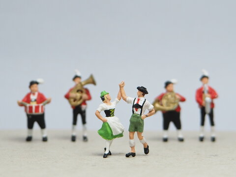 Mini toy of action figure at outdoor with blurred background. Miniature photography concept design. Minifigure of man and woman character dancing together at home.
