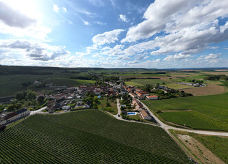 Trois-Puits, Reims, Marne, Grand-Est, France, August, 28th, 2025, Champagne Area, A stunning aerial view showcasing a picturesque, charming village set amidst vineyards beneath a dramatic sky
