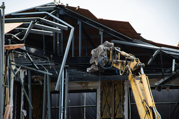 鉄骨カッターのアタッチメントを付けた重機での解体工事