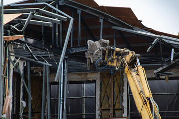 鉄骨カッターのアタッチメントを付けた重機で鉄骨を切断している