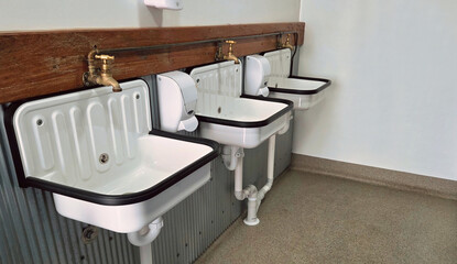 row of hand basins in a utility room , commercial bathroom