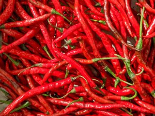 Bright red chili peppers, freshly harvested and densely packed together, showcasing their intense color and characteristic shape, ideal for spicy dishes.