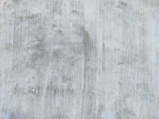 Fototapeta premium A smooth concrete or stucco wall, exhibiting soft gray and pale white tones with subtle vertical brush strokes and staining, providing a versatile, minimalist, and weathered industrial background.