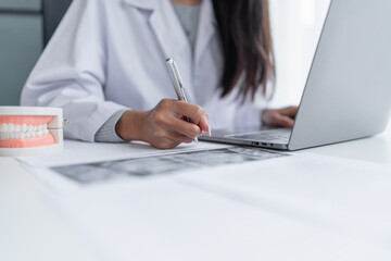 Dentist at dental clinic White healthy tooth with Dental model in oral surgeons discussing jaw...