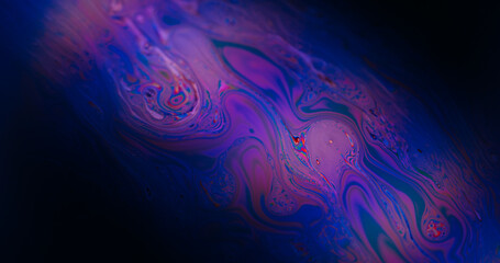 Obraz premium Defocused emulsion spill. Acrylic ink. Blue purple pink color flow oil bubble floating on abstract dark black creative art neon background.