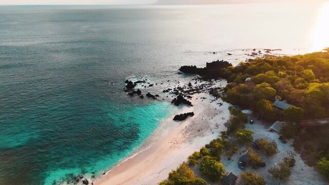 Top-down aerial drone footage of a secluded beach cove with turquoise water and crashing waves.