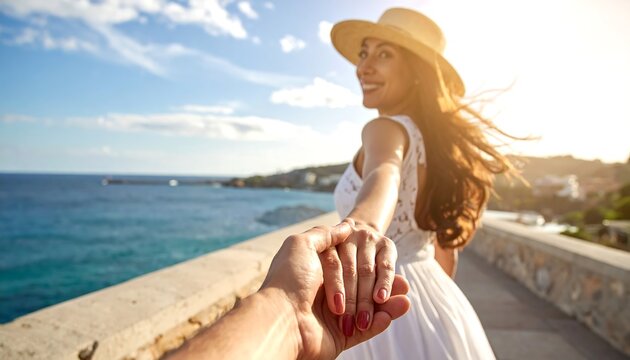 Smiling woman in white dress holds hand while walking toward sea
