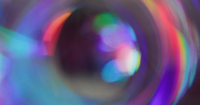 Iridescent blur glow. Whirl futuristic flare. Red purple blue light mixing color on black background. Neon reflection abstract luminosity.