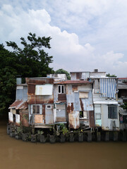 old shanty style houses on Southeast asian canal in Ho Chi Minh City made from odd sheets of corrugated iron. 