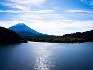 精進湖と富士山の絶景　秋晴れの空に映える紅葉と静かな湖面の美しい風景