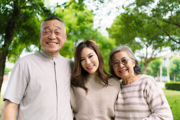 Fototapeta premium Asian family living together in park showing love, relationship and bonding.