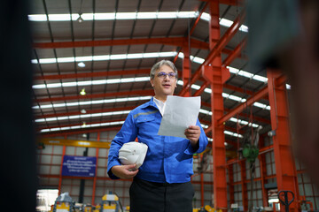 Diverse group of engineers and factory workers attending a morning briefing