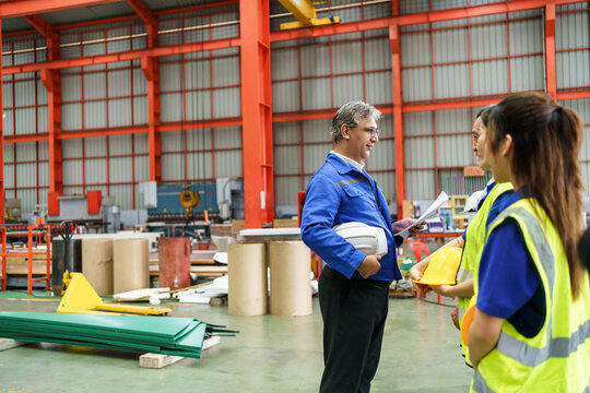 Diverse group of engineers and factory workers attending a morning briefing