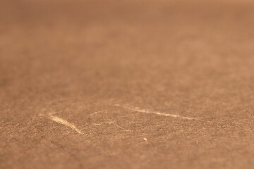 Close-up of a textured brown paper texture surface with subtle scratches.
