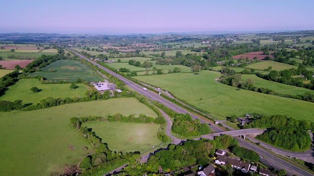 Aerial drone flight over the A30 road near Honiton in Devon facing West towards Exeter