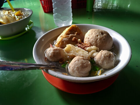 A hearty serving of meatballs in clear, tasty soup garnished with beef trimmings