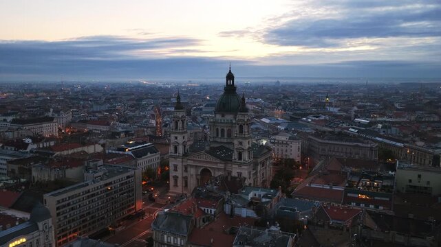 The majestic St. Stephen&rsquo;s Basilica dominates the skyline as Budapest glows under a dramatic evening sky.