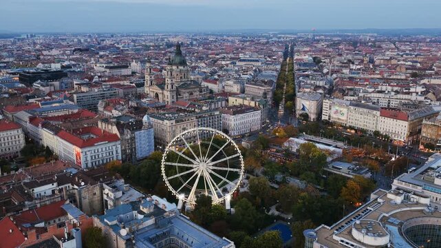 Budapest Eye and St. Stephen&rsquo;s Basilica rise amid the city&rsquo;s grand boulevards and historic rooftops at twilight.