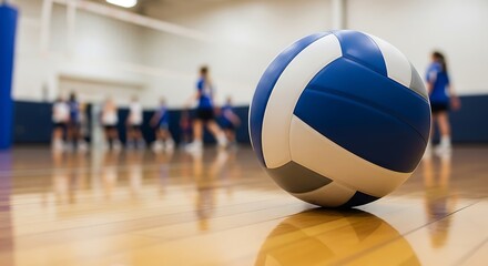 A focused shot of a volleyball with players blurred in the background