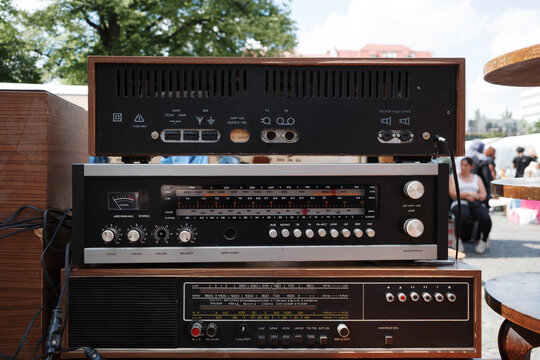 Close-up of three stacked vintage German audio receiver components at an outdoor flea market.
