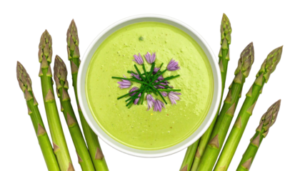 Green soup in bowl, flanked by asparagus spears